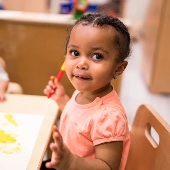 Little girl painting at table 