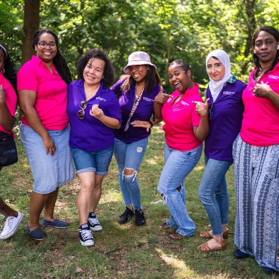Staff standing together in pink and purple shirts