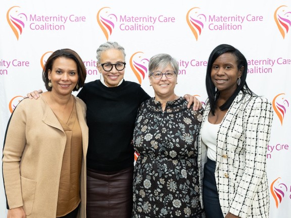 (L-R) Tamala Edwards, Linda Villarosa, Karen Pollack, Samia Bristow posed smiling together in front of MCC background