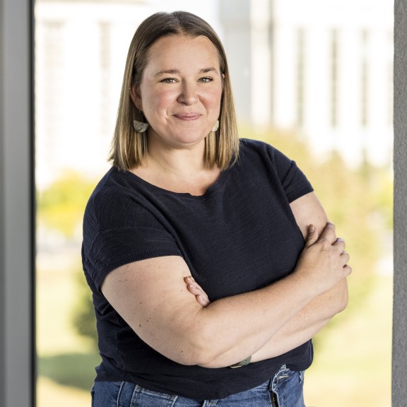 Samantha Harclerode with natural backdrop, short sleeve black shirt, arms crossed.