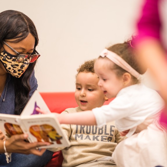 woman reading children a book