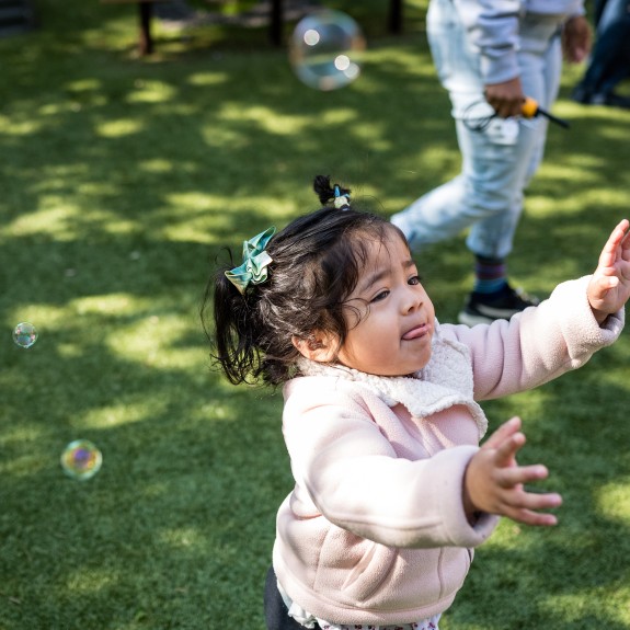 Little baby girl chasing bubbles