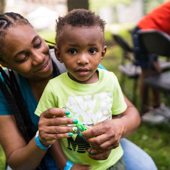 woman hugging child and blowing bubbles