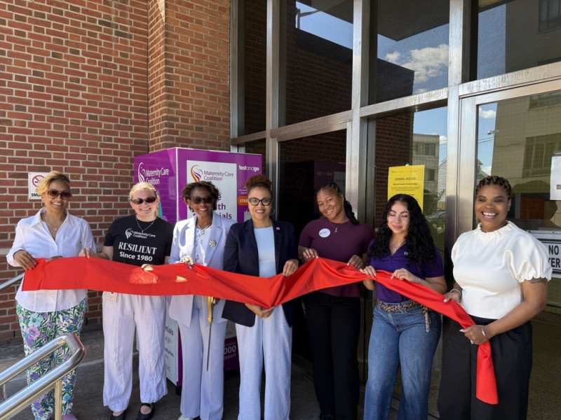 group of women cutting red ribbon