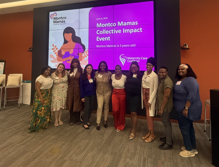 Staff smiling and standing in line in front of large event slide