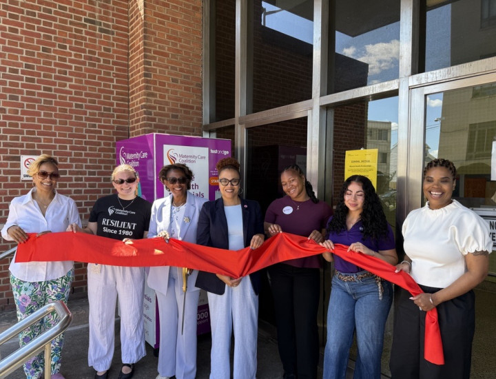 group of women cutting red ribbon